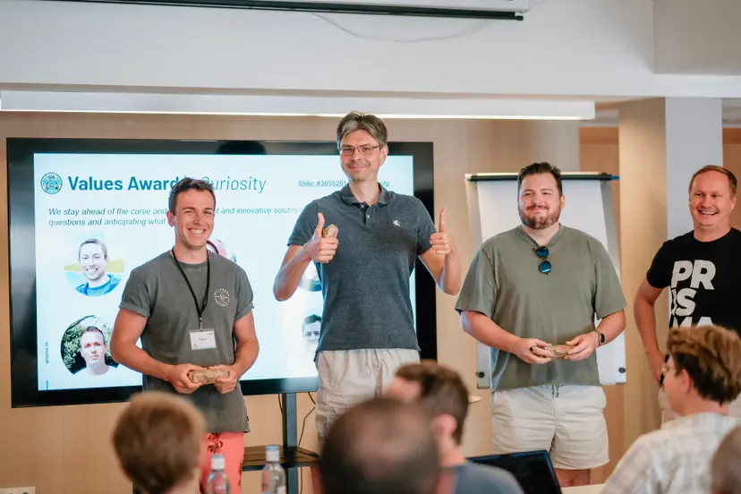 Three Prisma team members receiving a Values Award at a company event